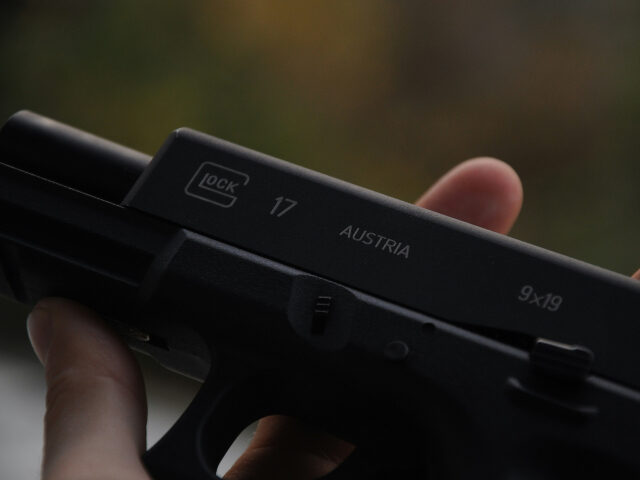 person-holding-black-semi-automatic-pistol