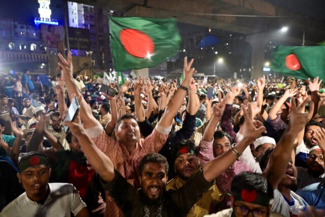 Bangladeshis celebrate after the interim government officially banned all activities of th