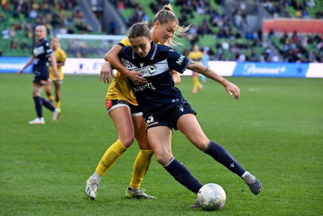 Central Coast Mariners' Sarah Rowe (L) and Melbourne Victory's Claudia Bunge tussle for th