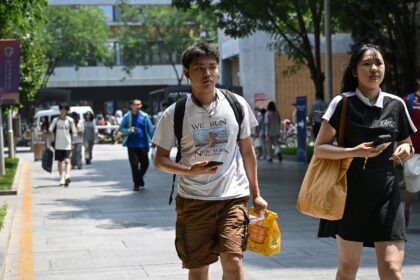 A Chinese student wearing a New York marathon t-shirt walks at Beijing Foreign Studies Uni