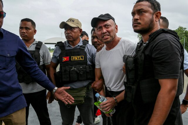 Filipino national Arnolfo Teves (2nd R), a murder suspect, is escorted by East Timorese se