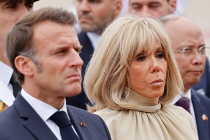 Grim day: France's President Emmanuel Macron and his wife Brigitte Macron at a wreath-layi