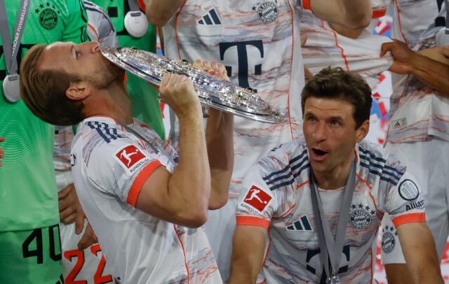 Harry Kane kisses the Bundesliga shield as his Bayern Munich teammate Thomas Mueller looks