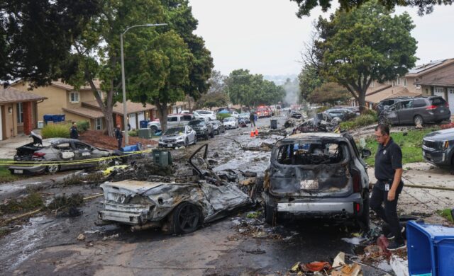 Investigators look through the site where a small plane crashed in San Diego, California o