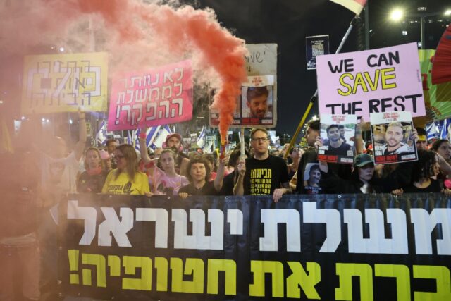 Israelis carry posters of hostages during an anti-government protest calling for an end to