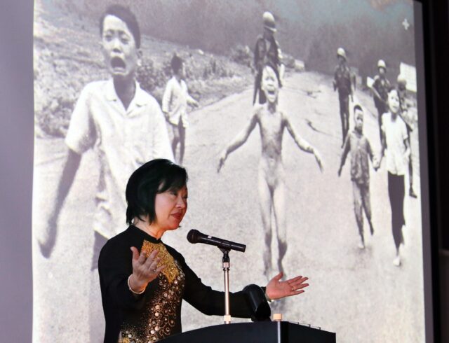 Kim Phuc stands beside the 1972 Pulitzer winning photograph of her running naked and burnt