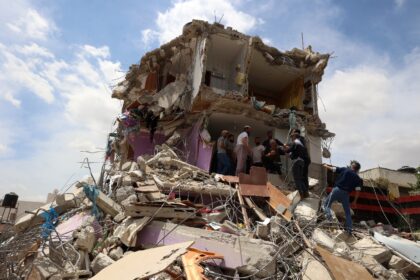 Palestinians inspect the damage at a house following an Israeli raid in the occupied West