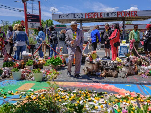 People laid yellow roses at a mural dedicated to George Floyd during part of the anniversa