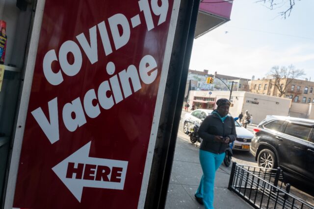 A pharmacy advertises the COVID-19 vaccine as the nation marks the fifth anniversary of th