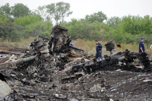 Rescuers stand on July 18, 2014 on the site of the crash of a Malaysian airliner carrying