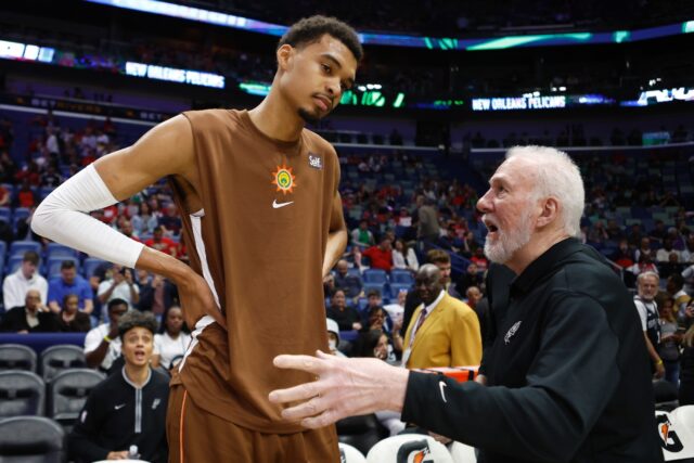 San Antonio Spurs star Victor Wembanyama, left, listens to advice from Gregg Popovich, who