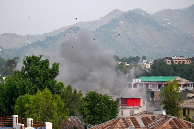 Smoke billows after an artillery shell landed in the main town of Poonch district in India