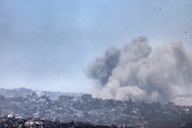Smoke billows over destroyed buildings during an Israeli bombardment in Gaza on Friday