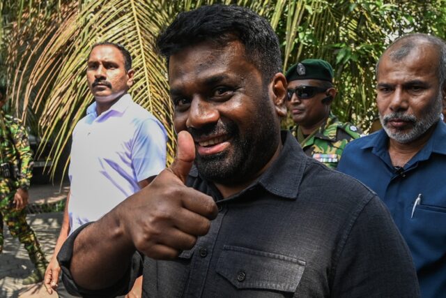 Sri Lanka's President Anura Kumara Dissanayake (C) leaves a polling station after casting