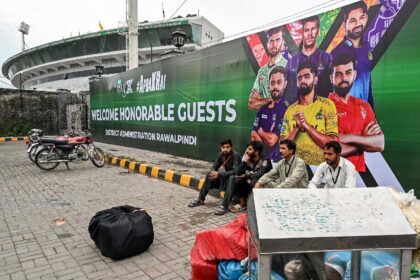 Vendors pack their belongings as they leave Rawalpindi Cricket Stadium following the postp