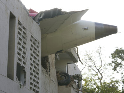 The debris of an airplane sticks out of a building after it crashed in India's northw