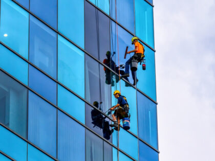 Two window washer men working on the facade of the Greektown Casino and Hotel. (Photo by R