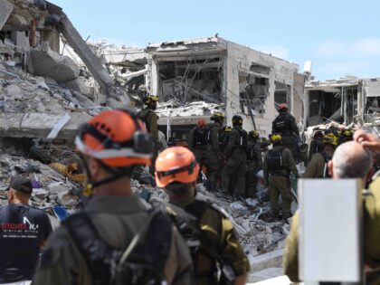 Rescue teams inspect a damaged building following a strike by an Iranian ballistic missile