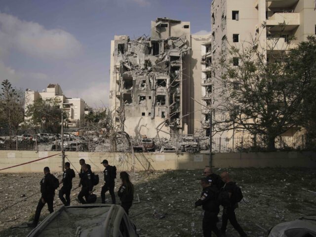 Police officers inspect residential buildings destroyed by an Iranian missile strike that