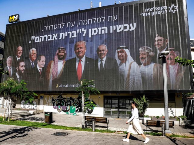 TOPSHOT - A woman walks past a billboard displayed in Tel Aviv on June 26, 2025 by the &qu