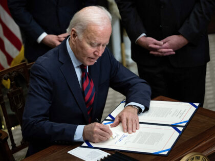 US President Joe Biden signs a resolution to avert a nationwide rail shutdown, in the Roos