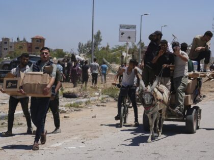 Palestinians carry boxes and bags containing food and humanitarian aid packages delivered