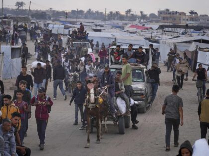 Palestinians carry bags filled with food and humanitarian aid provided by the Gaza Humanit