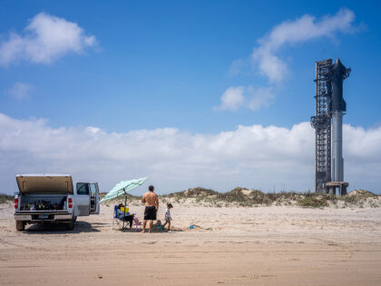 A family spends time together on the shore near the Starship Flight 3 Rocket a day before