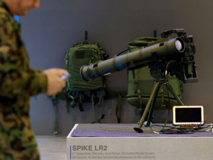 A member of the Swiss army walks past a Spike LR2 Long-Range Missile during a presentation