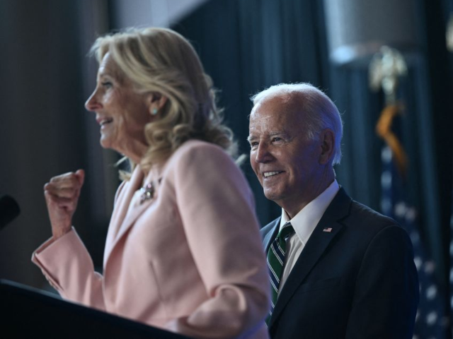 US President Joe Biden looks on as First Lady Jill Biden speaks at a Biden Cancer Moonshot