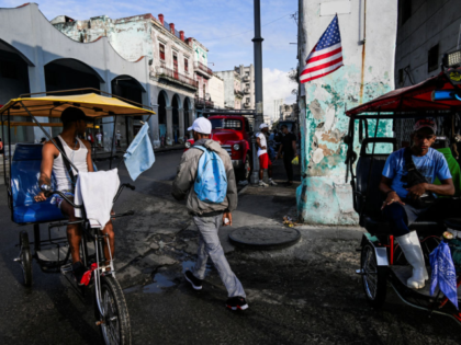 A man waits for passengers on a bike used as taxi and decorated with an UA flag on a stree