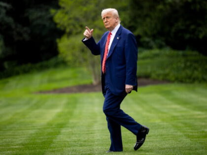 US President Donald Trump walks on the South Lawn of the White House before boarding Marin