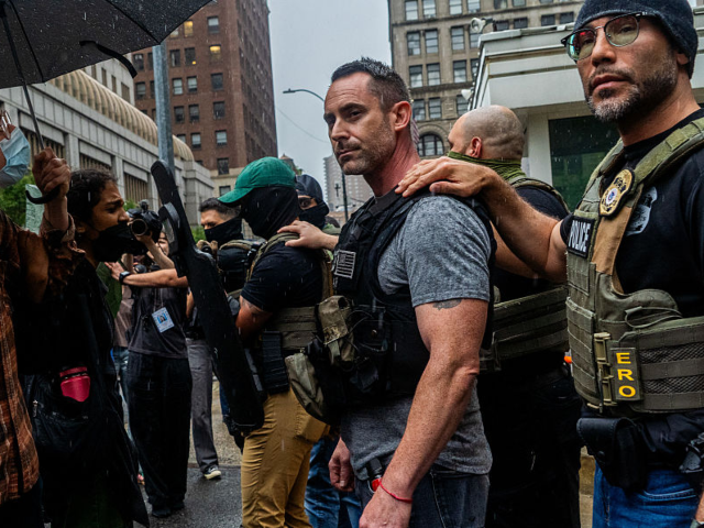 Protestors and ICE agents stand face to face in a tense standoff outside 26 Federal Plaza