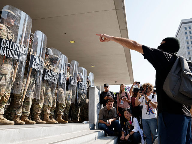 The California National Guard holds a line in front of anti-ICE protesters in front of the