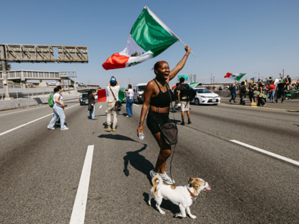 A protester shouts while waving a Mexican flag as protests continue in Los Angeles on June