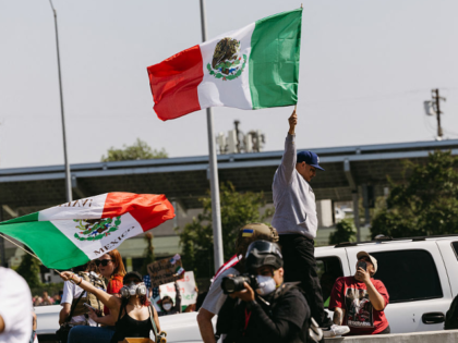 A protester waves a Mexican flag as protests continue in Los Angeles on June 10, 2025, fol