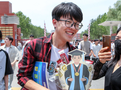 JIAOZUO, CHINA - JUNE 09: A gaokao candidate receives gifts from his families outside an e