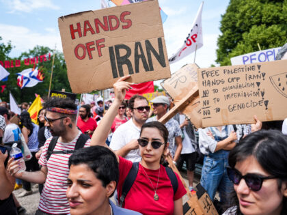 A protestor holds signs during a demonstration against the government of Israel ahead of t