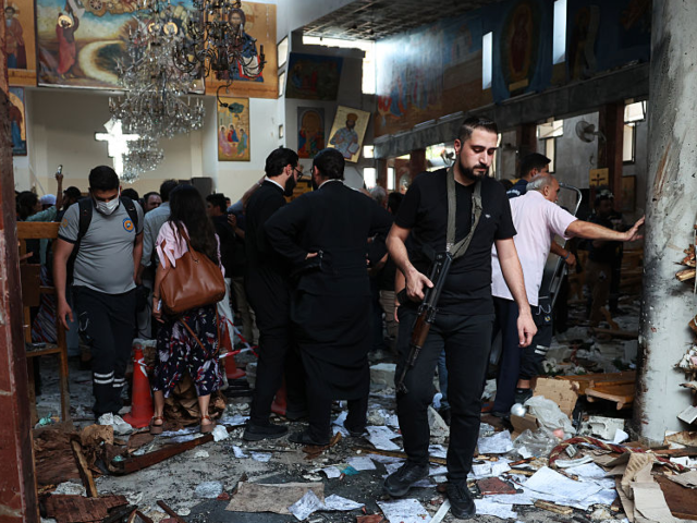 GettyImages-2221526346 DAMASCUS, SYRIA - JUNE 22: An armed man inspects damage at the Mar Elias Church following