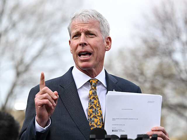 Energy Secretary Chris Wright holds a copy of "Energy, Economic, and Environmental Assessm