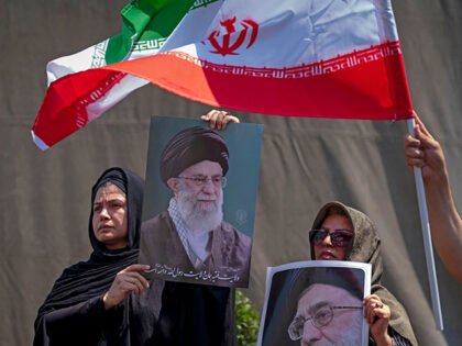 Iranian worshippers hold portraits of Iran's Supreme Leader, Ayatollah Ali Khamenei, and a