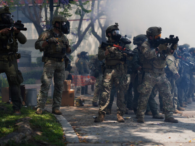 Law enforcement stand during a protest in the Paramount section of Los Angeles, Saturday,