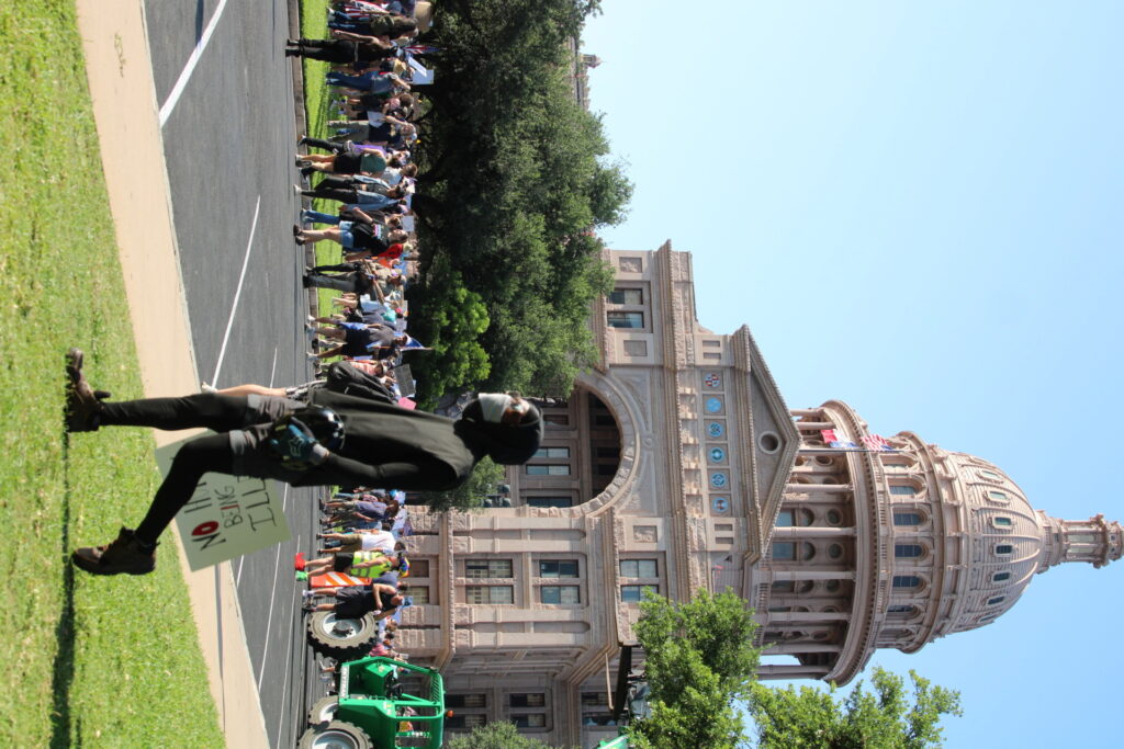 Masked protesters carry helmets across Texas capital grounds at the Democratic No King Slurry (Randy Clark/Breitbart Texas)