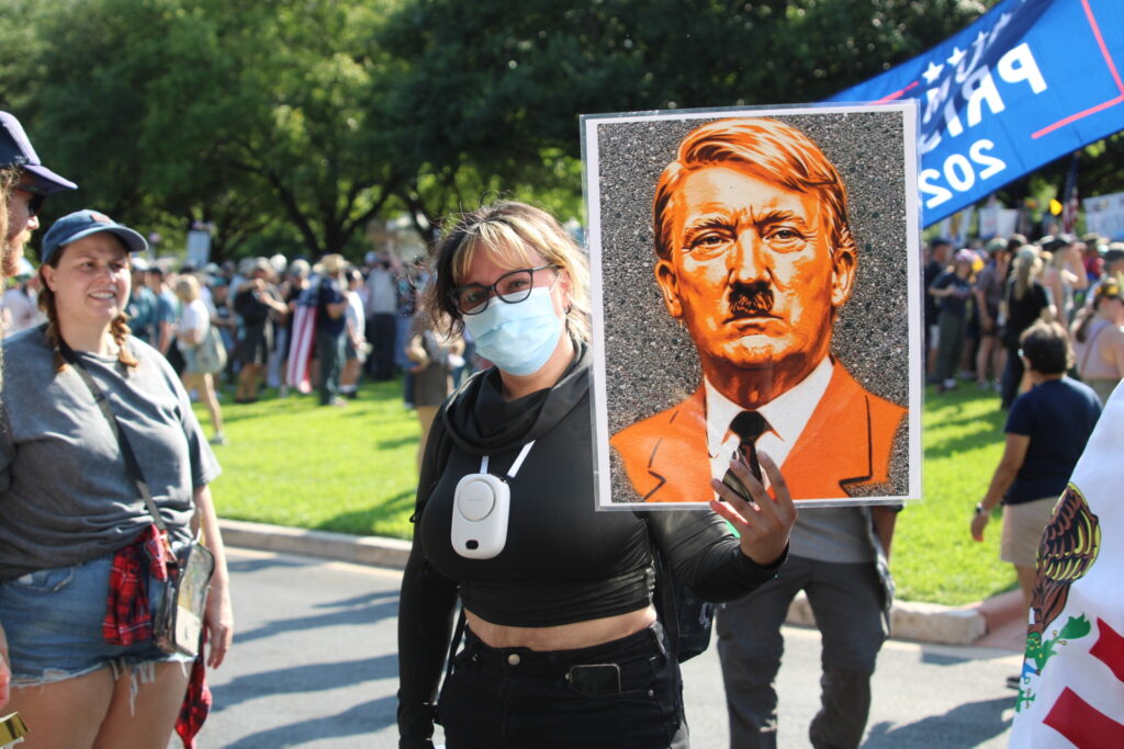 Protesters with Randy Clark's portrayal of President Trump as a Hitler photograph (Randy Clark/Breitbart Texas)