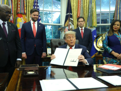 U.S. President Donald Trump sigs a letter of congratulations as he meets with Minister of