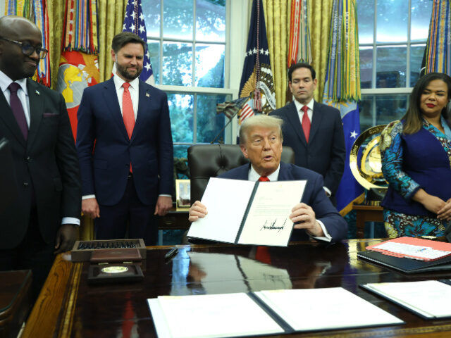 U.S. President Donald Trump sigs a letter of congratulations as he meets with Minister of