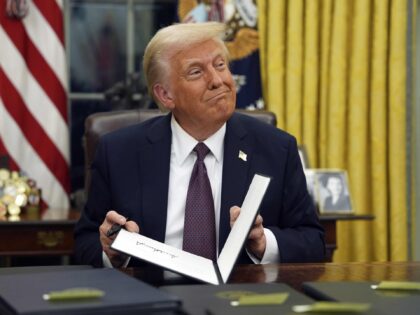 FILE - President Donald Trump signs executive orders in the Oval Office of the White House