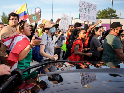 Protesters speak to authorities after the arrest of a man detained by police during an imm