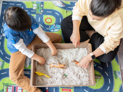 A Professional Child Psychologist Doing Sand Therapy With Little Boy