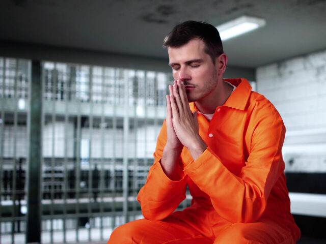 man praying in prison